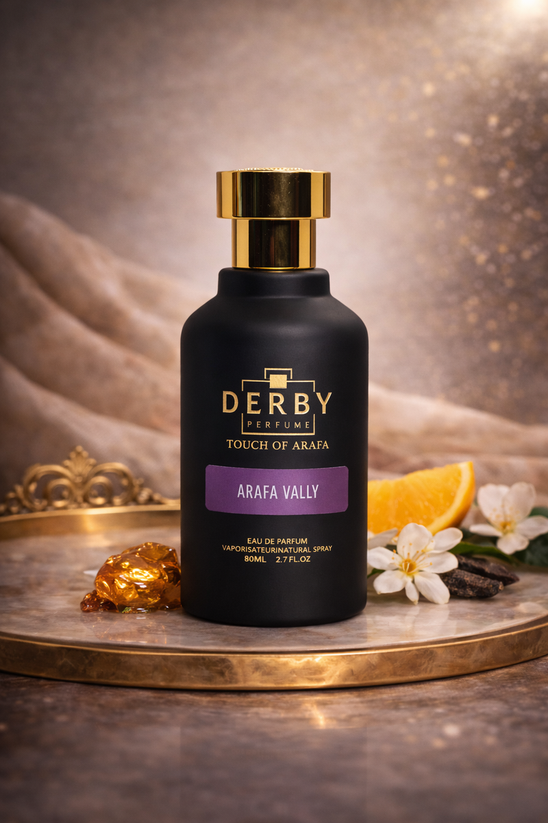 Black perfume bottle with gold cap on a decorative tray with flowers and orange slice