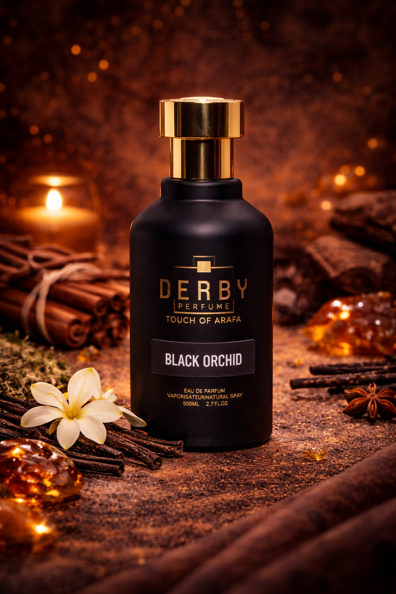 Black perfume bottle with gold cap labeled 'Derby Perfumes' on a wooden surface with spices and flowers.